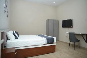 a bedroom with a bed and a desk and a television at Ravi Convention Centre in Rājānagaram +10 photos