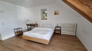 a bedroom with a bed and a wooden floor at NRAR Hotel Hirschen in Beromünster