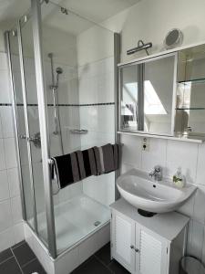 a white bathroom with a sink and a shower at Albbruck, Feriendomizil Albsteig in Albbruck