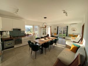 a kitchen and living room with a table and chairs at Aura Vendégház in Révfülöp