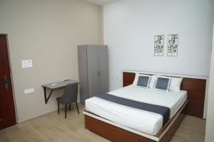 a bedroom with a bed and a desk and a table at Ravi Convention Centre in Rājānagaram