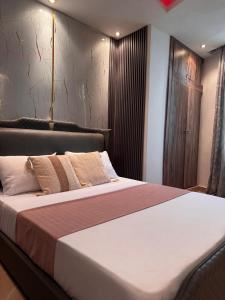 a bedroom with a large bed with brown and white sheets at Chez Charly in Kinshasa
