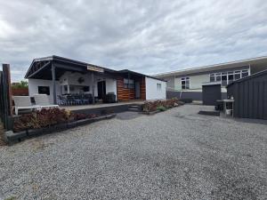 a building with a porch and chairs in a parking lot at Howsthaserenitee - 3BR house with bay views in Coffin Bay