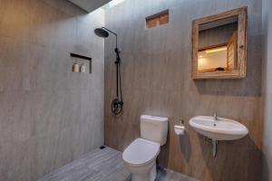 a bathroom with a toilet and a sink at Ratih Guest House in Ubud +46 photos