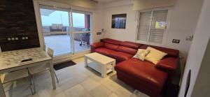 a living room with a couch and a table at Espectacular ático en 1°linea playa in Rota