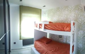 two bunk beds in a room with a window at Espectacular ático en 1°linea playa in Rota +23 photos
