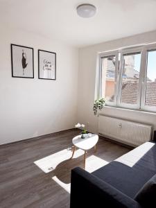 a white living room with a couch and a table at District B Apartments in Brno