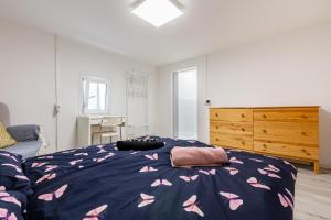 a bedroom with a bed with pink butterflies on it at Immensee Appartments by Mainka Properties in Immensee
