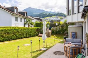 a patio with an umbrella in the yard of a house at Immensee Appartments by Mainka Properties in Immensee