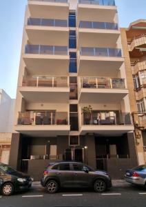 a building with cars parked in front of it at Lassa Holiday Apartament in Torrevieja