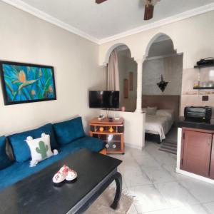 a living room with a blue couch and a table at Studio Relax in Dakhla