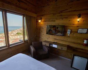 a bedroom with a bed and a tv and a chair at Sarı Köşk Hotel in Rize