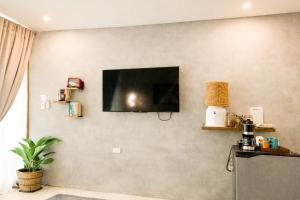 a living room with a television on a wall at Moringa Private Room in General Luna +3 photos