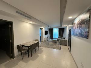 a living room with a table and chairs and a couch at Pinnacle Row Panoramic 2BR Oasis in Muscat