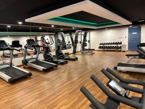 a gym with a bunch of treadmills and ellipticals at Pinnacle Row Panoramic 2BR Oasis in Muscat