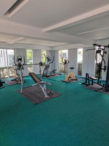 a gym with several tread machines and green carpet at Eid and Philippe's Home building A9 in Ban Ko Kwang