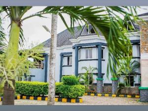 ein blaues Haus mit Palmen davor in der Unterkunft Brava Hotel in Ibadan