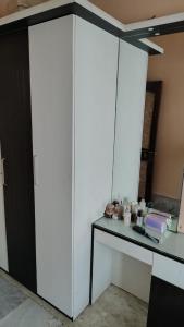 a room with a white cabinet and a table at Gem Backpackers Hostel in Siliguri