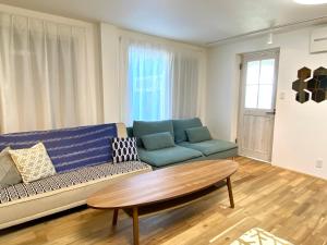 a living room with a blue couch and a coffee table at プチリゾート・ひじきwest in Hijiki +11 photos