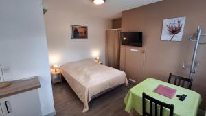 a small hotel room with a bed and a table at Résidence L'IDEALE in La Roche-Posay