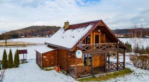 a small wooden cabin with snow on the roof at Zielona Dolinka in Kostrzyca
