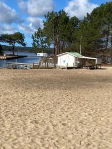 a small shack on a beach next to a body of water at Mobilhome 592 FUNPASS NON INCLUS in Gastes