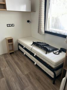 a bed in a room with a window at Mobilhome 592 FUNPASS NON INCLUS in Gastes +10 photos