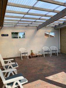 a group of chairs sitting on a patio with a roof at VØ Budget Drop Inn in Thisted