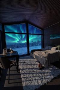 a bedroom with a bed and a view of the northern lights at Mystical Lapland Suite in Rovaniemi