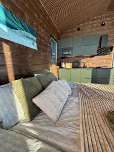 a bedroom with a bed with pillows and a kitchen at Mystical Lapland Suite in Rovaniemi +11 photos