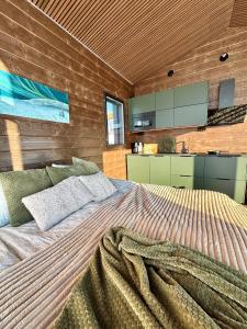 a bedroom with a large bed and a kitchen at Mystical Lapland Suite in Rovaniemi