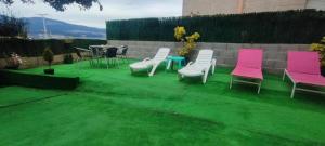 a group of chairs and a table on a lawn at Hospedaje Villa Blas in Redondela