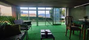 a living room with green carpet and a table and chairs at Hospedaje Villa Blas in Redondela