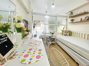 a room with a bed and a table with plates on it at Little Treasure Tagaytay-Flora in Tagaytay