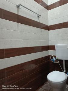 a bathroom with a toilet and brown and white stripes at Kaushlendra Bhawan in Ayodhya