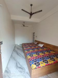 a bed in a room with a ceiling fan at Kaushlendra Bhawan in Ayodhya +9 photos