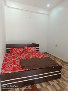 a bedroom with a bed with red pillows on it at Kaushlendra Bhawan in Ayodhya