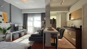 a kitchen and living room with a bed and a table at Divine Studio Fermei 62 in Popeşti-Leordeni
