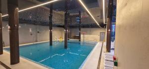 ein großes Schwimmbecken mit einer Person, die darin spielt in der Unterkunft Hotel SKAL Medi SPA & Resort in Ustronie Morskie