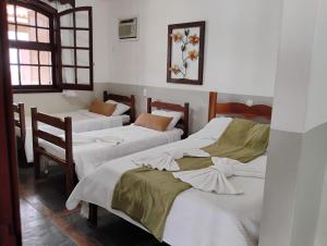 a room with three beds and two windows at Pousada MG in Tiradentes +42 photos