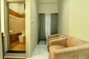 ein Wohnzimmer mit Sessel und ein Badezimmer in der Unterkunft Zoho Suites in Kochi