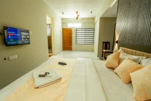 ein Schlafzimmer mit einem großen Bett und einem Fernseher an der Wand in der Unterkunft Zoho Suites in Kochi + 144 Fotos