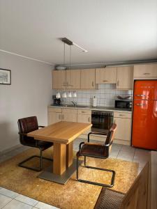 a kitchen with a wooden table and two chairs at Haus Jansen in Korschenbroich +4 photos