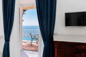 a room with a view of the ocean from a balcony at La Bizantina Luxury Villa in Positano