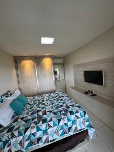 a bedroom with a large bed and a flat screen tv at Flat com linda vista no Monte Castelo in Sairé