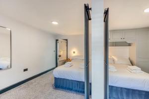 a bedroom with two beds and a mirror at Botanic Cottages in Southport