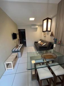 a living room with a glass table and a couch at Flat com linda vista no Monte Castelo in Sairé