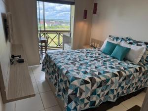 a bedroom with a bed with a view of a balcony at Flat com linda vista no Monte Castelo in Sairé