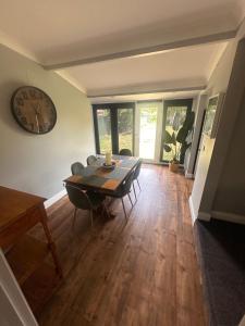 a dining room with a table and a clock on the wall at Wattle Cottage in Cootamundra