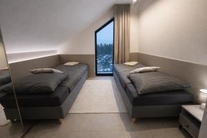 a bedroom with two beds and a large window at Oaza Radęcin in Woldenberg Neumark